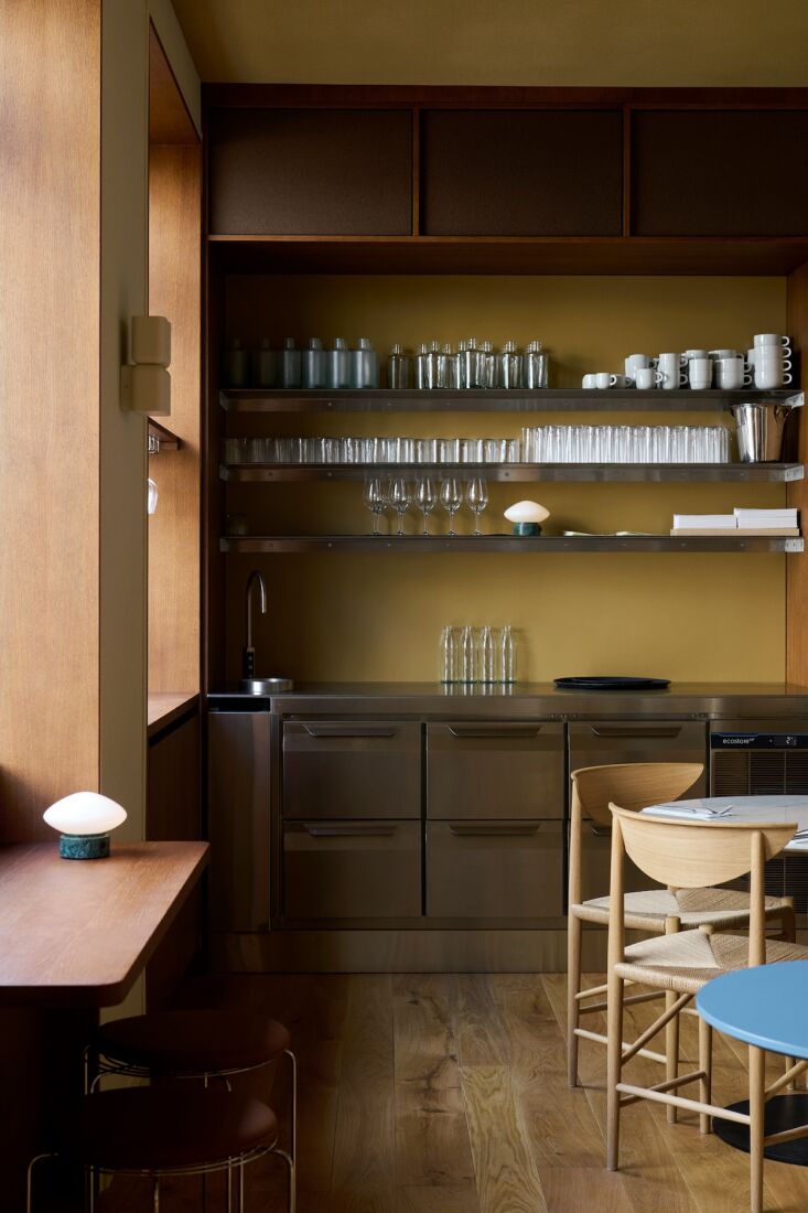 a stainless steel prep kitchen. to the right, oiled oak drawn chairs by hvidt & 20